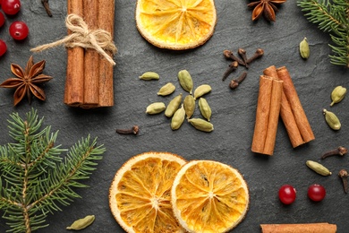 Photo of Flat lay composition with mulled wine ingredients and fir branches on black slate table