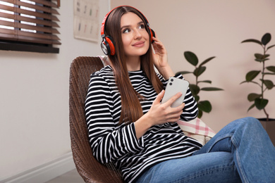 Photo of Woman listening to audiobook in chair at home