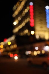 Photo of Blurred view of city street with lights at night. Bokeh effect