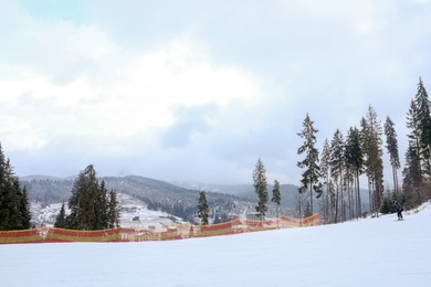 Photo of Small town near ski slope on snowy day. Winter vacation