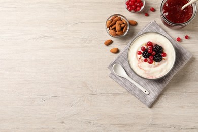 Photo of Delicious semolina pudding with berries on wooden table, flat lay. Space for text