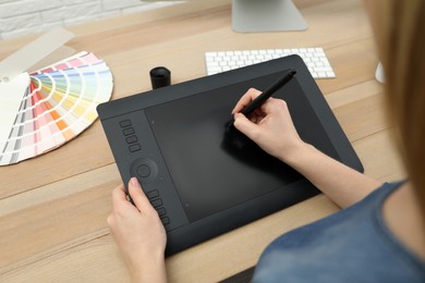 Photo of Professional designer working on graphic tablet at desk, closeup