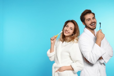 Photo of Portrait of young couple with toothbrushes on color background. Space for text