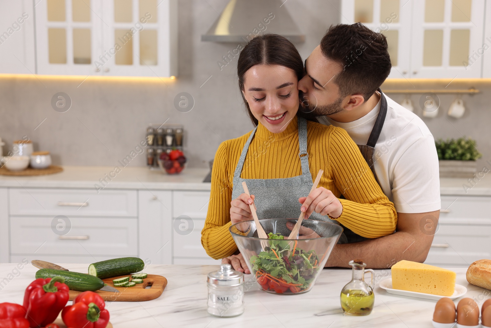 Photo of Lovely young couple cooking together in kitchen