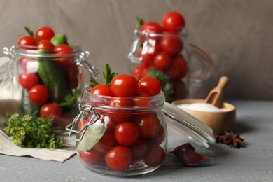 Photo of Pickling jars with fresh ripe vegetables on grey wooden table
