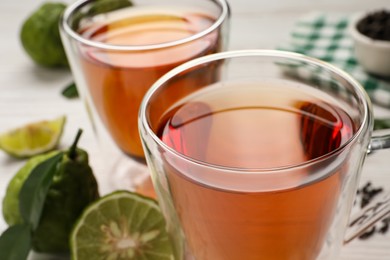 Photo of Glass cups of tasty bergamot tea on table, closeup