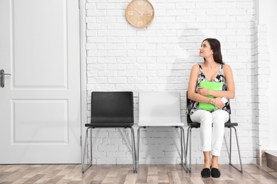 Photo of Young woman waiting for job interview, indoors