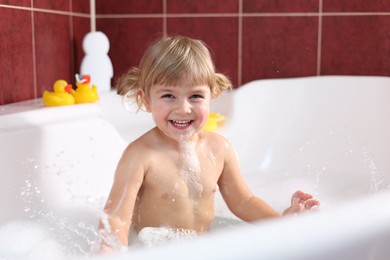 Photo of Happy girl bathing in tub at home