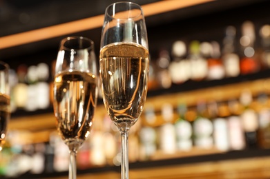 Glasses of champagne in bar, low angle view. Space for text