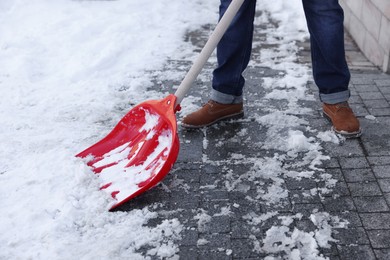 Photo of Man shoveling snow on city street, closeup
