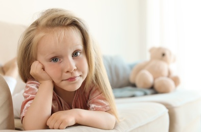 Photo of Portrait of pretty little girl on sofa in room