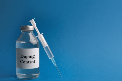 Drug and syringe on blue background, space for text. Doping control