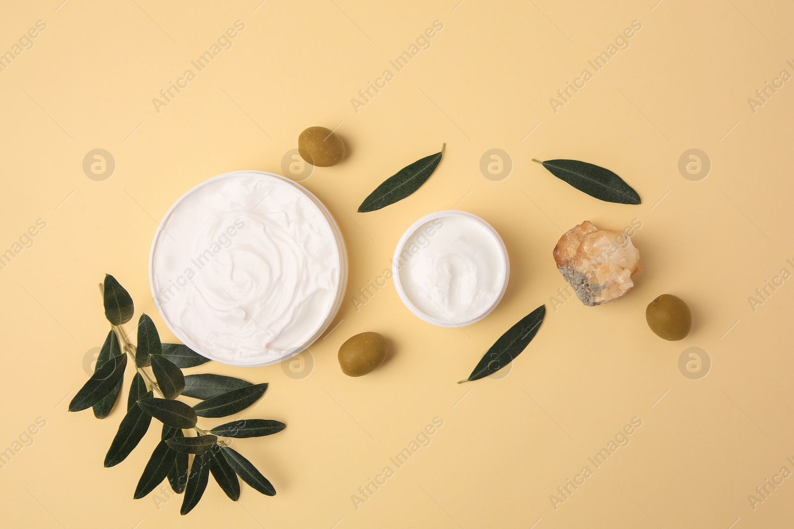 Photo of Natural cosmetic. Different olive creams, mineral and ingredient on beige background, flat lay