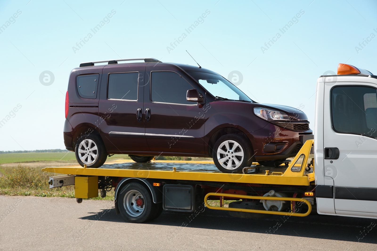 Photo of Tow truck with broken car on country road