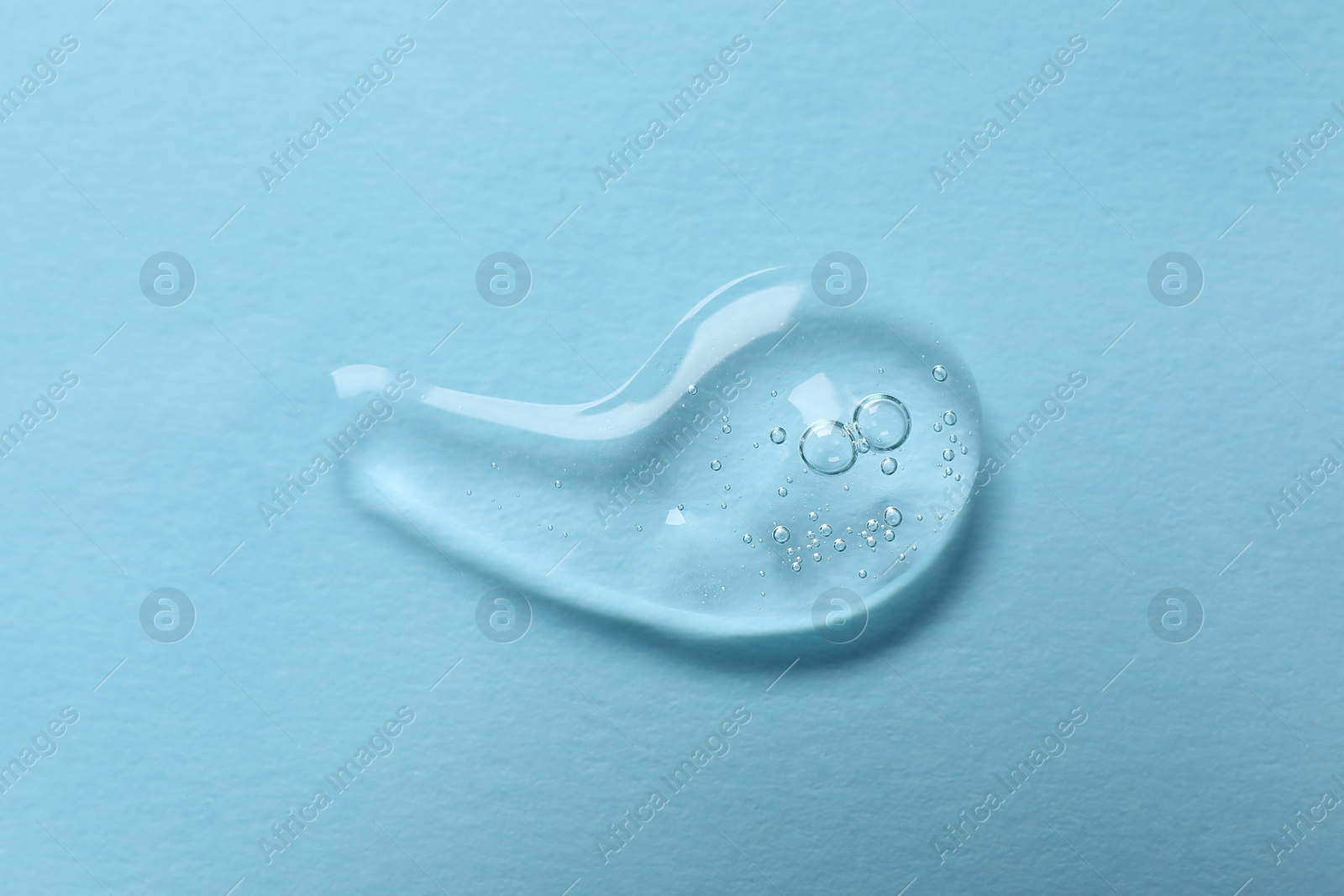 Photo of Sample of transparent gel on light blue background, top view