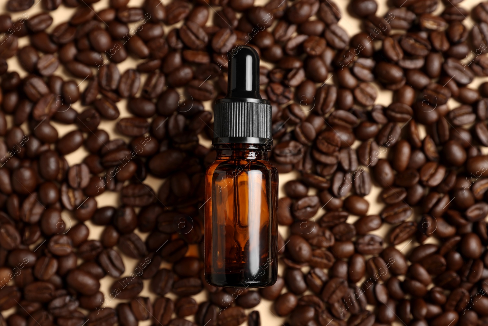 Photo of Bottle of organic cosmetic product and coffee beans on beige background, flat lay