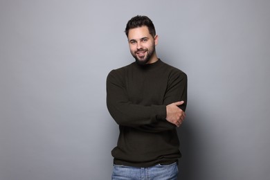 Photo of Happy man in stylish sweater on grey background