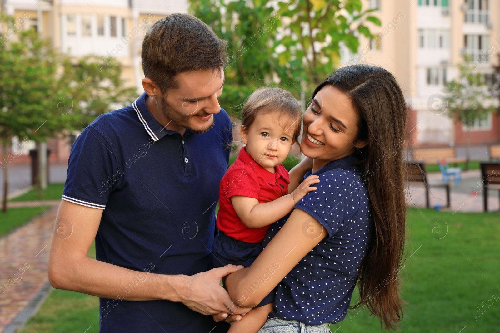 Photo of Happy family with adorable little baby outdoors