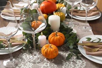 Photo of Beautiful autumn table setting. Plates, cutlery, glasses, pumpkins and floral decor