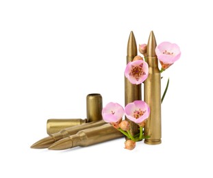 Photo of Bullets, cartridge cases and beautiful flowers isolated on white