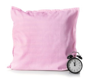 Soft decorative pillow and alarm clock on white background