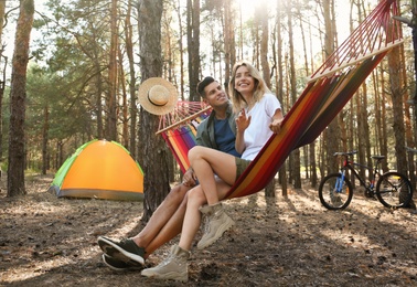 Photo of Couple resting in hammock outdoors on summer day