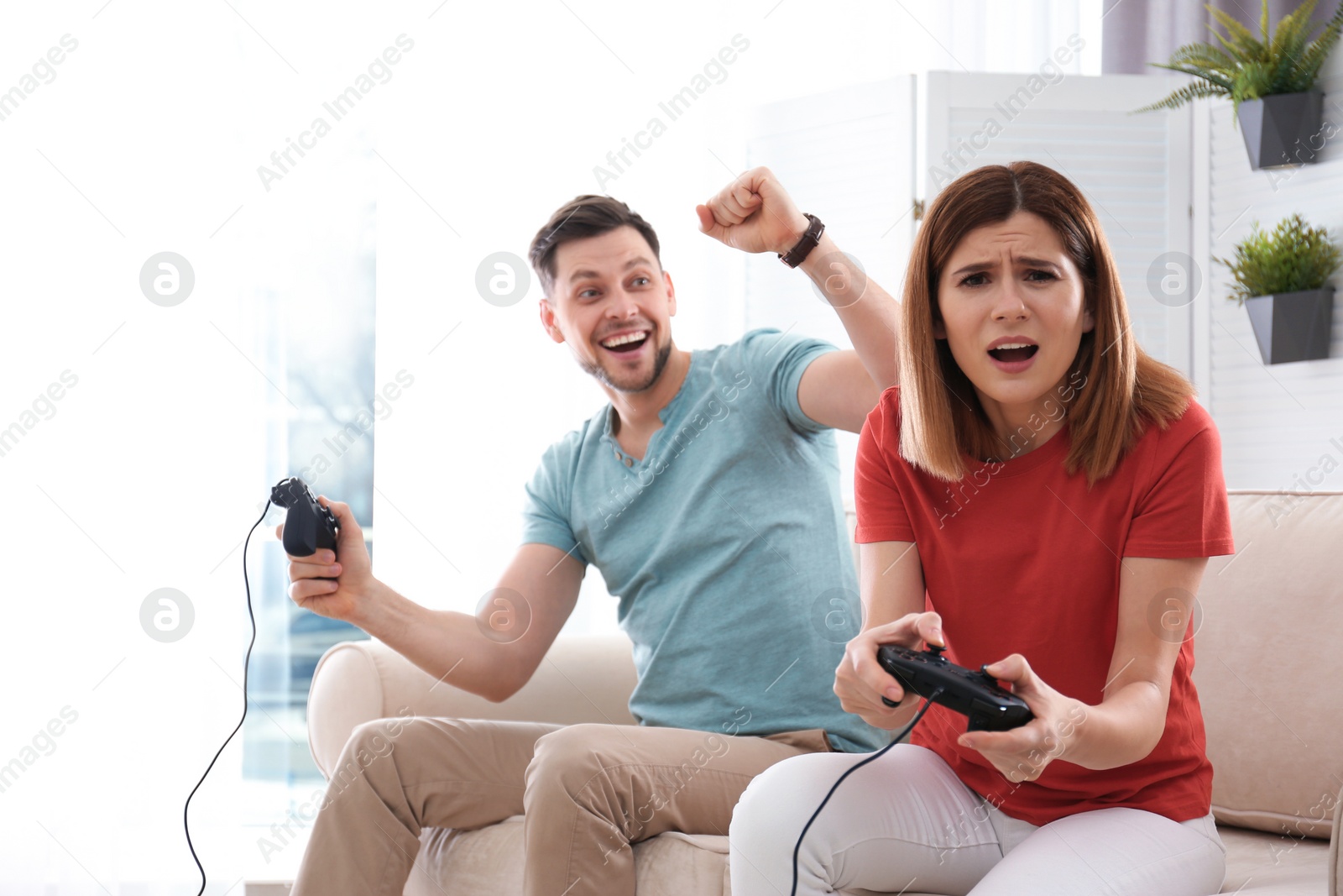 Photo of Happy couple playing video games in living room