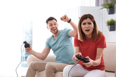 Photo of Happy couple playing video games in living room