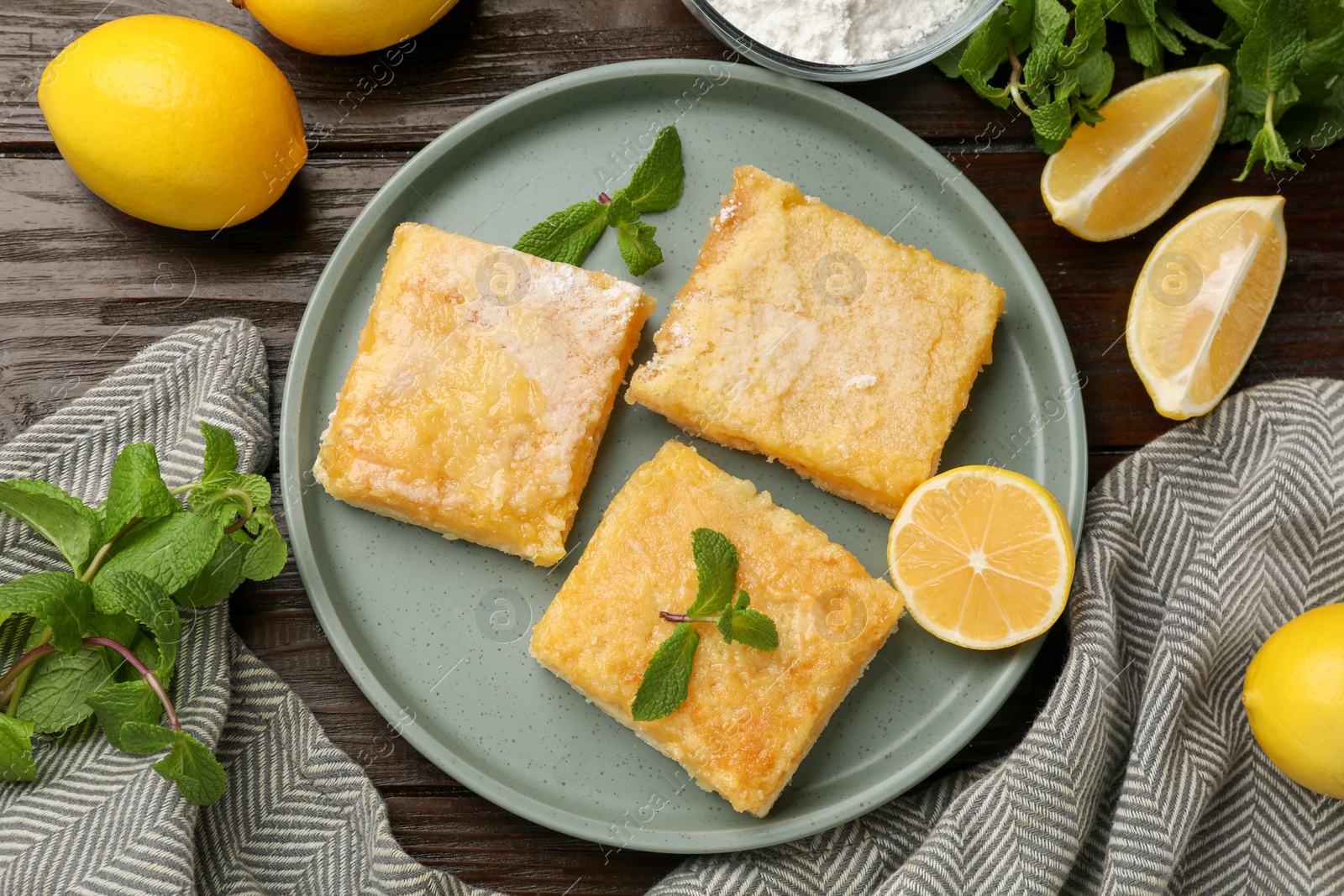 Photo of Tasty lemon bars served on wooden table, flat lay