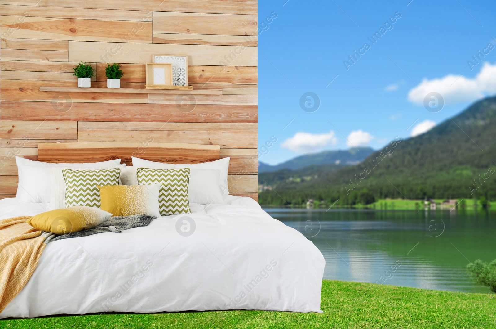 Image of Comfortable bed with soft pillows and picturesque view of river and mountains on background