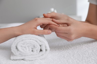 Woman receiving hand massage in wellness center, closeup