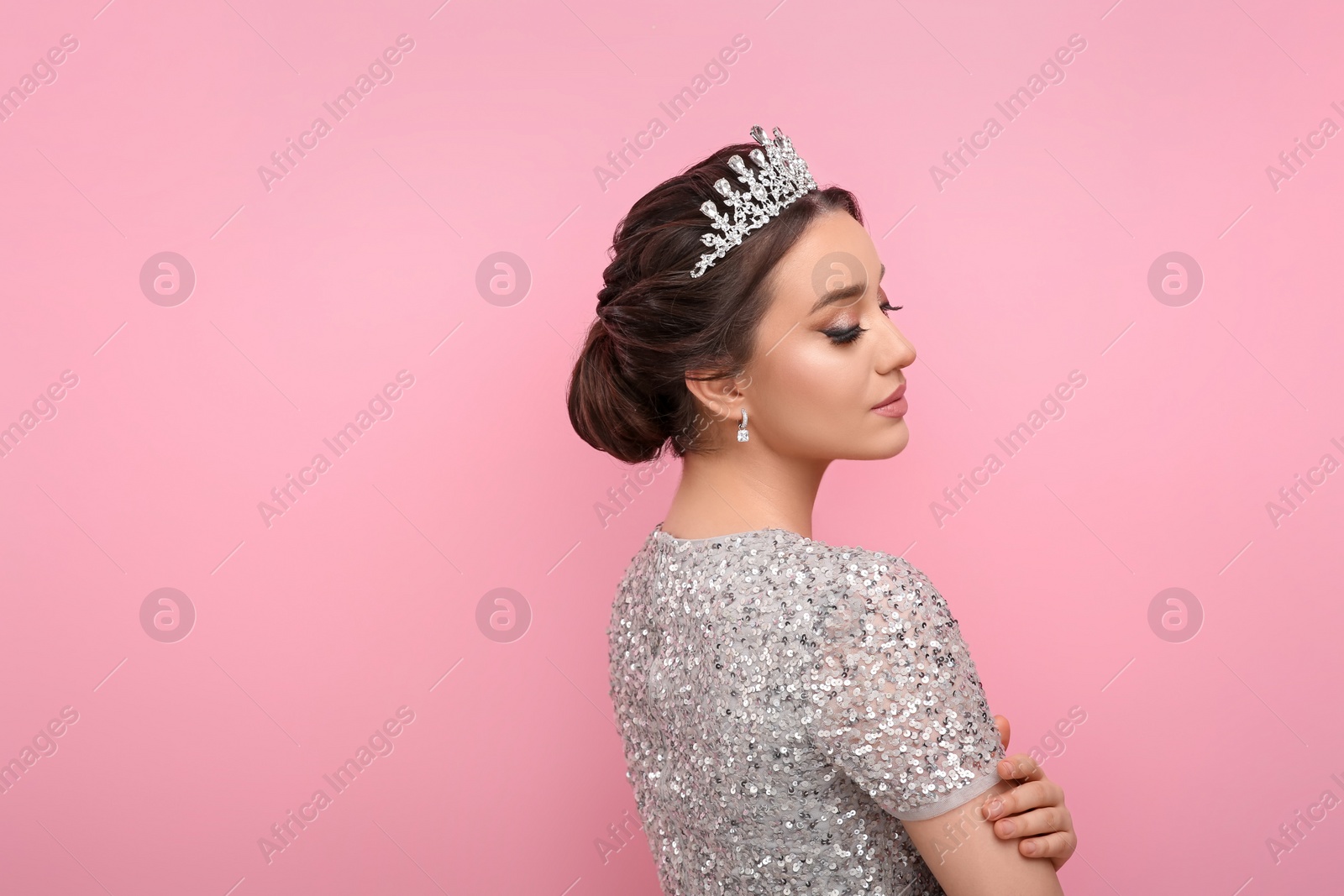 Photo of Beautiful young woman wearing luxurious tiara on pink background, space for text