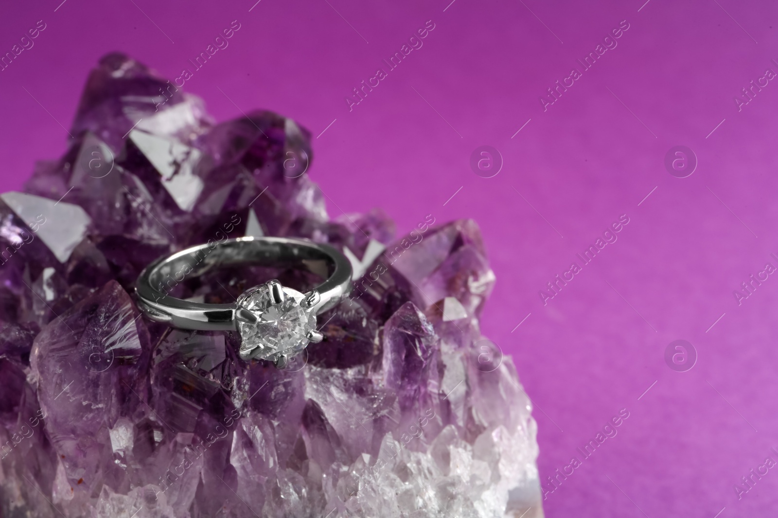 Photo of Beautiful luxury engagement ring with gemstone on amethyst, closeup