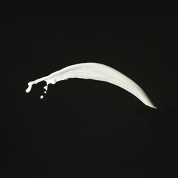 Photo of Splash of fresh milk on black background