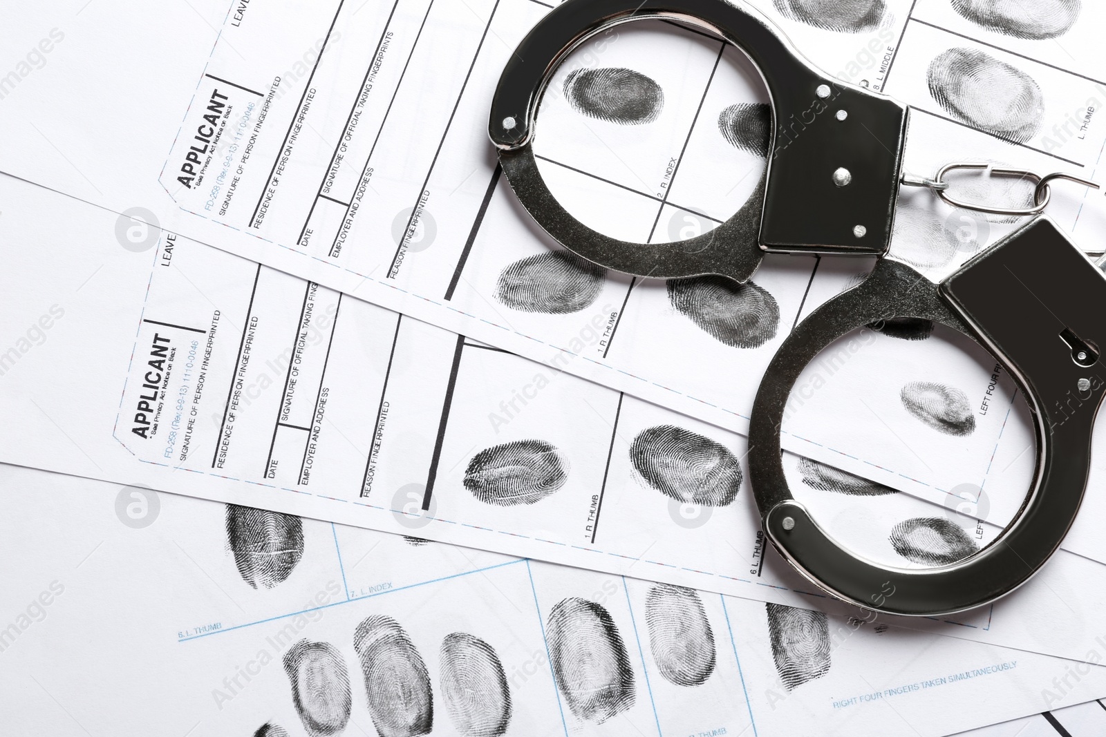 Photo of Handcuffs and fingerprint record sheets, top view. Criminal investigation