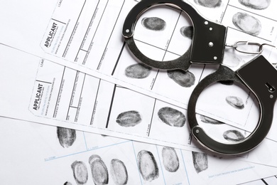 Photo of Handcuffs and fingerprint record sheets, top view. Criminal investigation