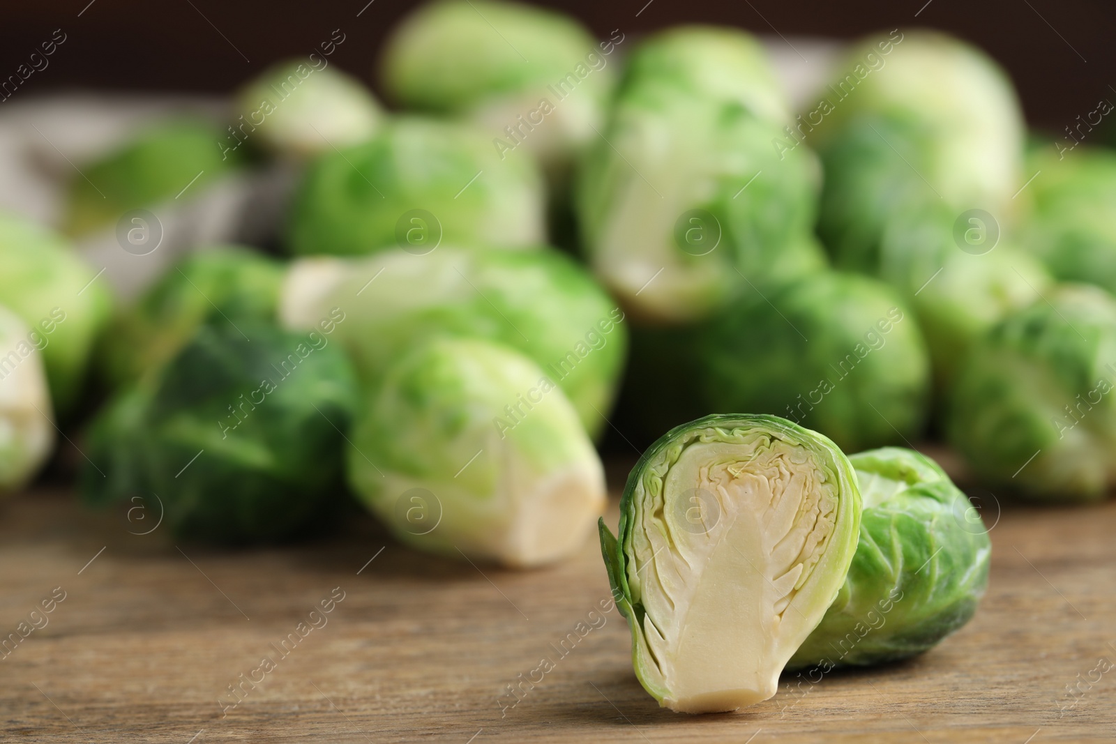 Photo of Fresh Brussels sprouts on wooden table, closeup