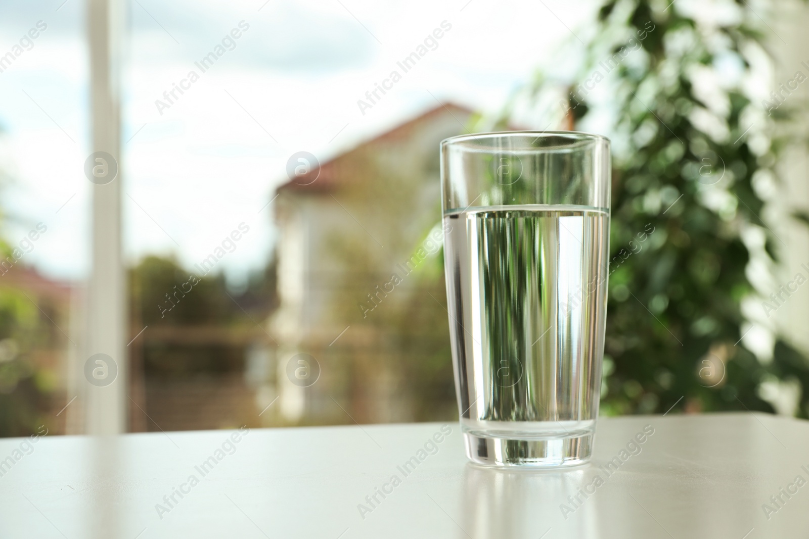 Photo of Glass of fresh water on table indoors. Space for text