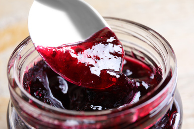 Image of Spoon with berry jam in jar, closeup