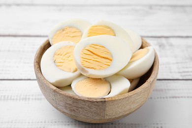 Bowl of fresh hard boiled eggs on white wooden table, closeup