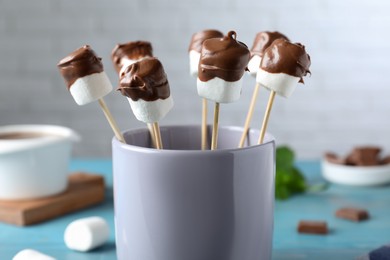 Photo of Delicious marshmallows covered with chocolate in cup, closeup