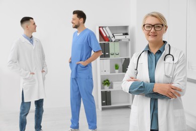 Photo of Portrait of doctor near colleagues in clinic