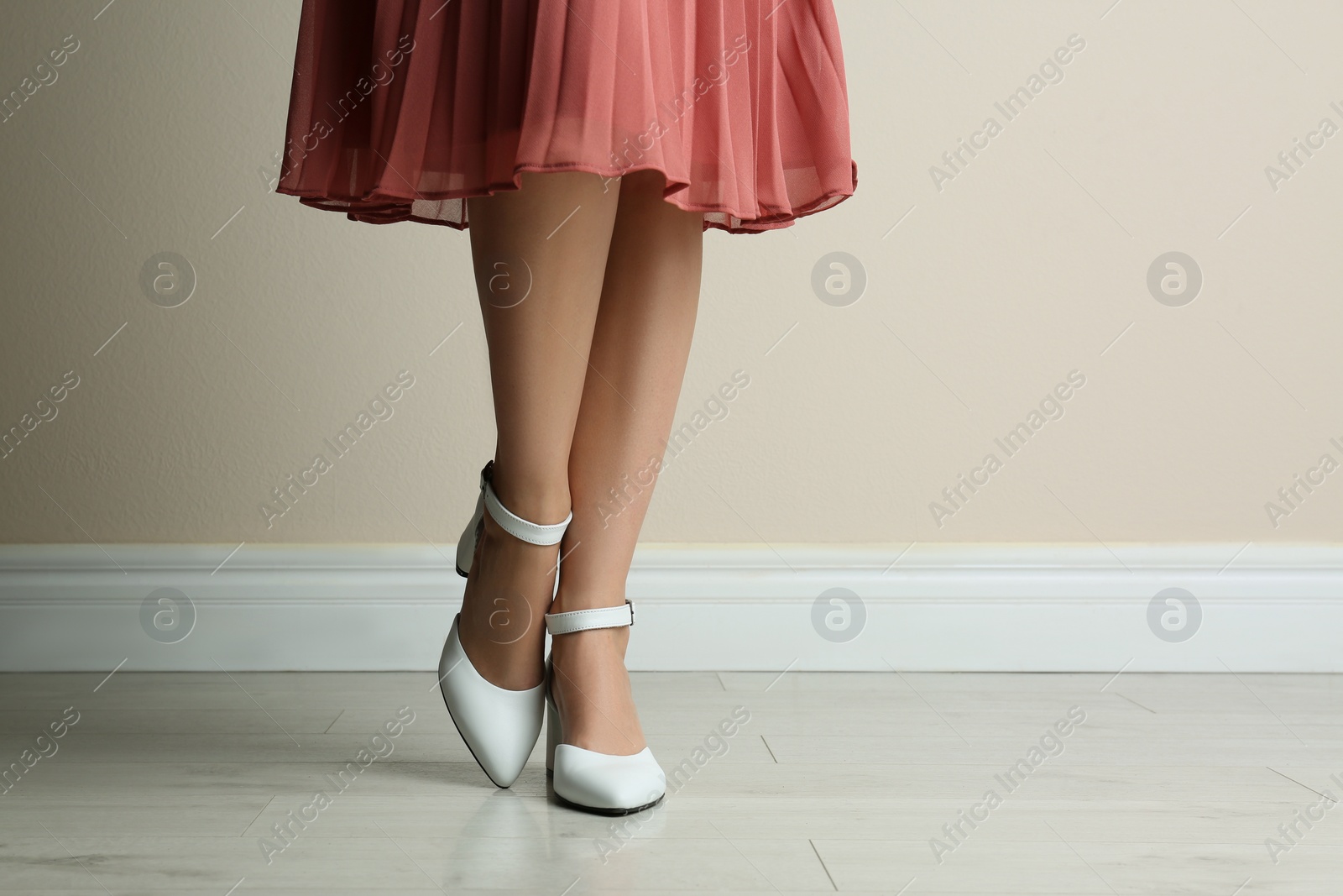 Photo of Woman wearing stylish shoes near beige wall indoors, closeup