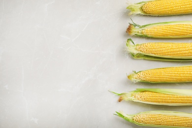 Photo of Tasty sweet corn cobs on table, top view