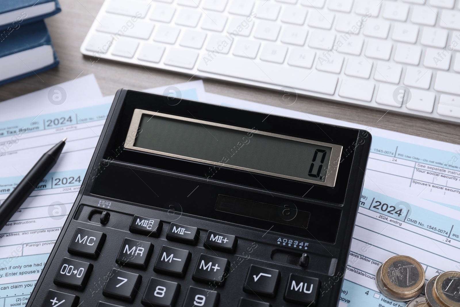 Photo of Tax accounting. Calculator, documents, coins, keyboard and pen on table, closeup