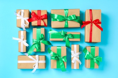 Christmas gift boxes with bows on light blue background, flat lay