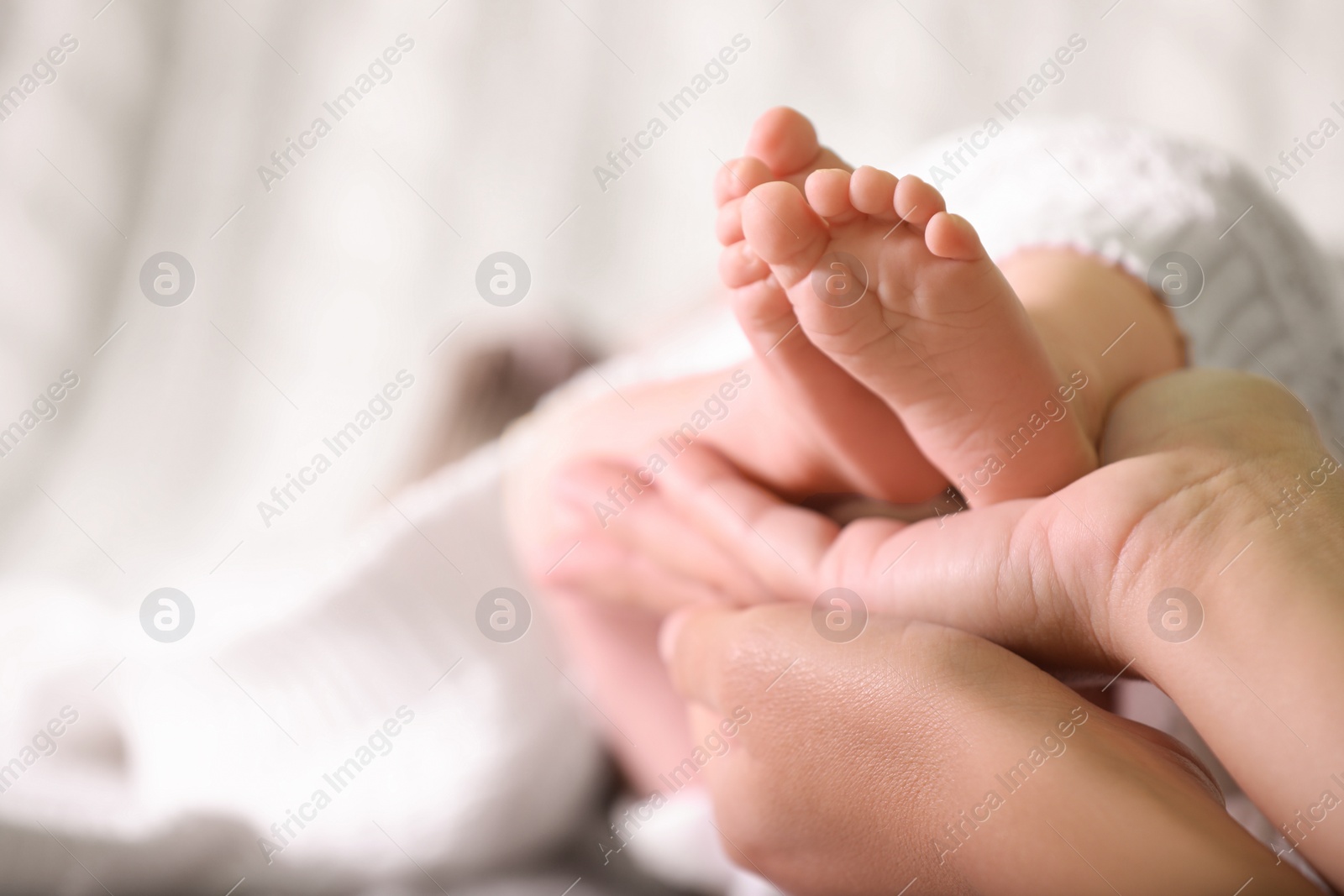 Photo of Mother and her newborn baby on bed, closeup. Space for text