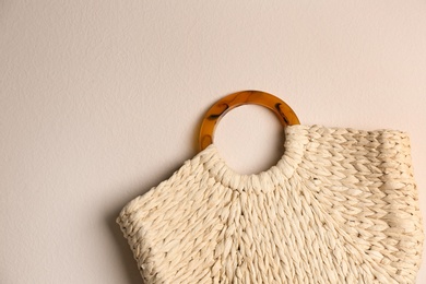 Elegant woman's straw bag on beige background, top view