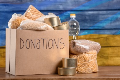 Image of Donation box, different products and Ukrainian flag on background. Help during war