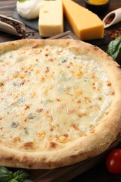 Photo of Delicious cheese pizza and ingredients on table, closeup